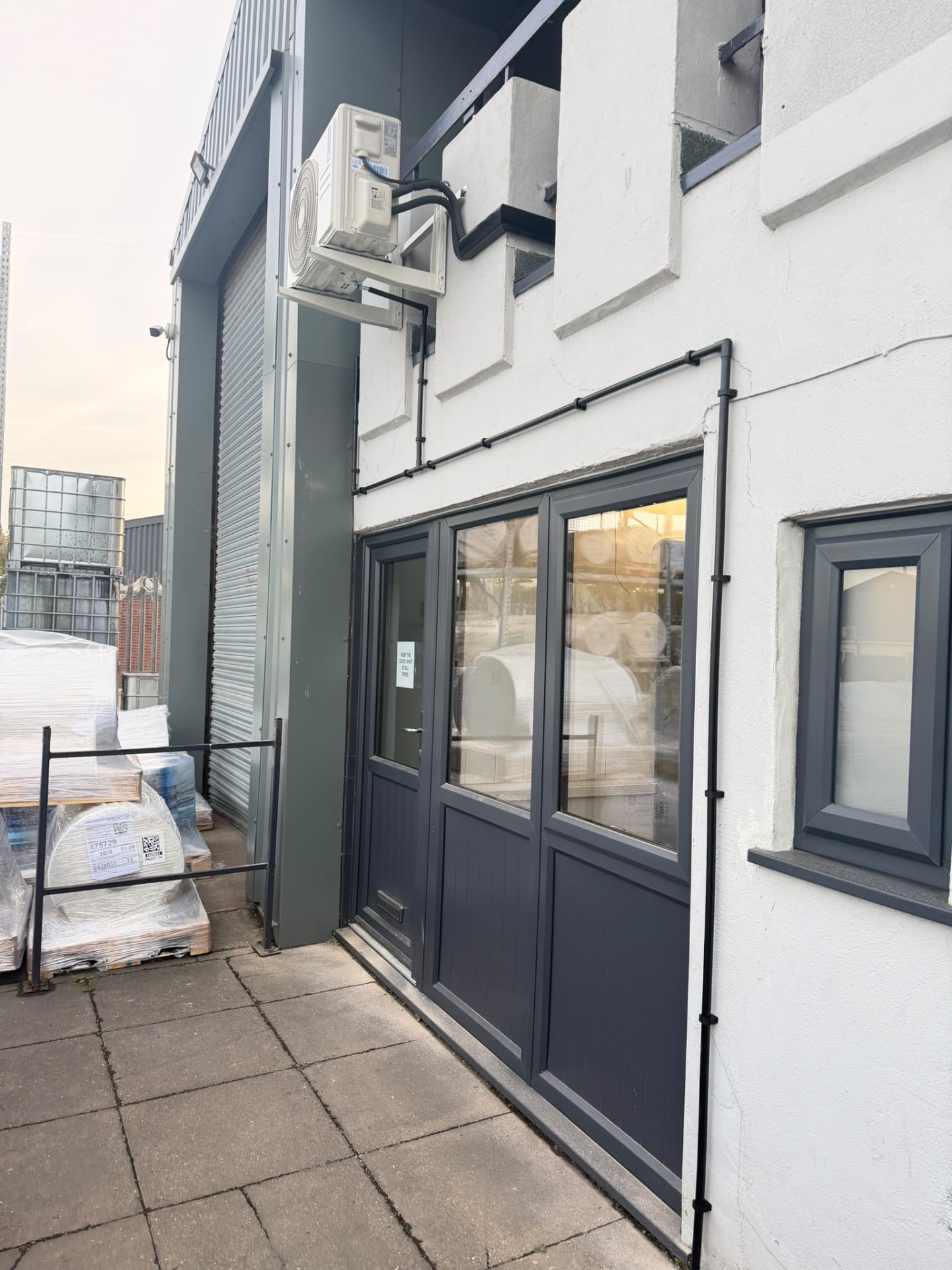 Black trunking running up the wall to the outdoor unit above the office entrance